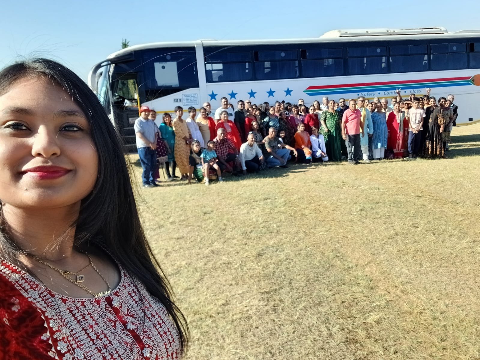 Group photo of pilgrims by the tour bus