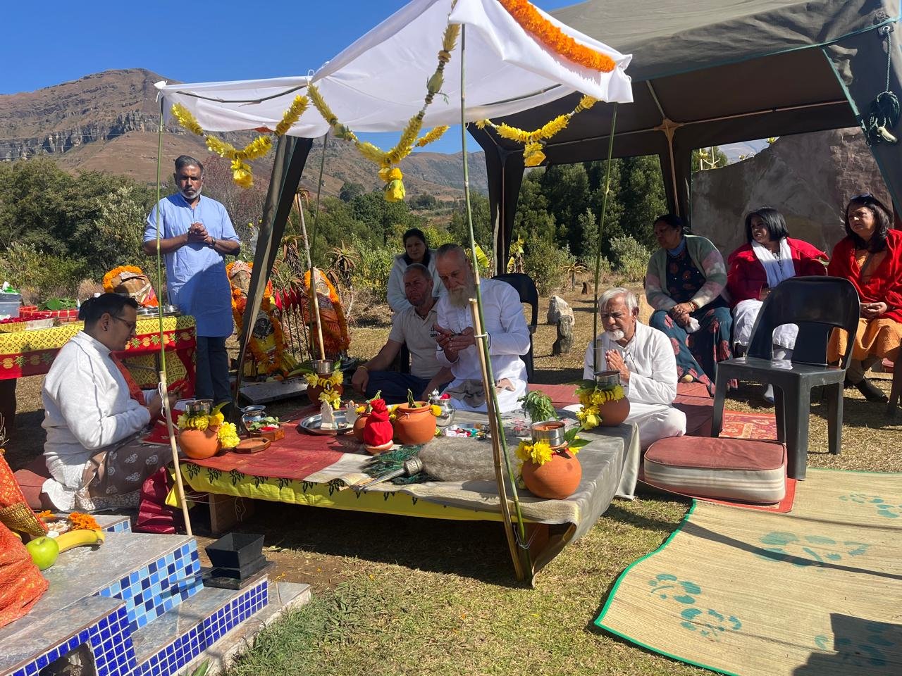 Puja ceremony under the tent with mountain backdrop